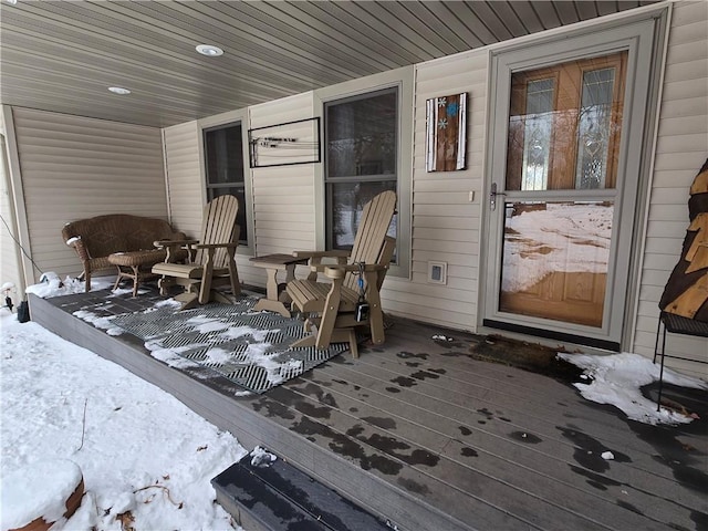 snow covered deck with a porch