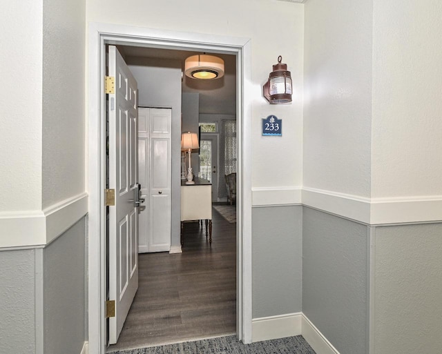 hallway featuring baseboards and wood finished floors