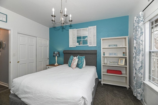 bedroom with baseboards, a closet, carpet flooring, and an inviting chandelier