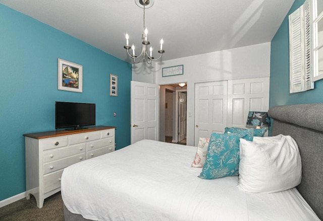 bedroom featuring a notable chandelier, dark colored carpet, and baseboards