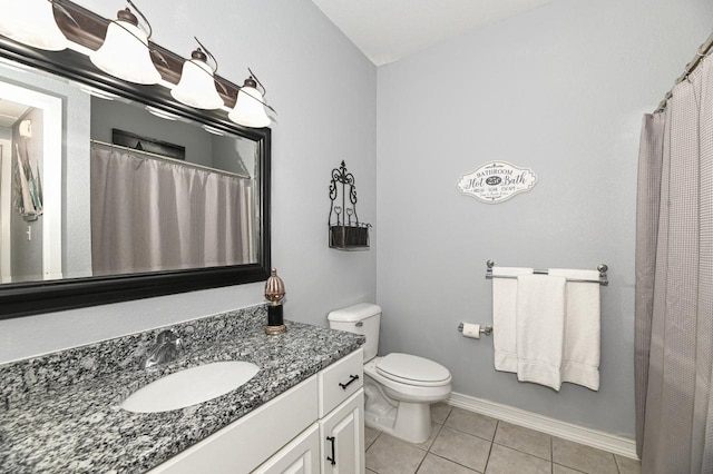 bathroom with toilet, baseboards, vanity, and tile patterned floors