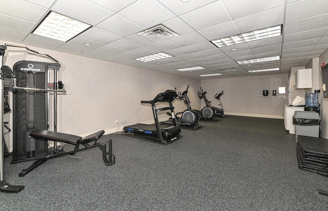 workout area featuring baseboards, visible vents, and a drop ceiling