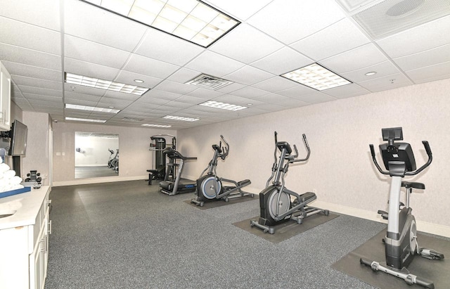 workout room featuring a paneled ceiling, visible vents, and baseboards