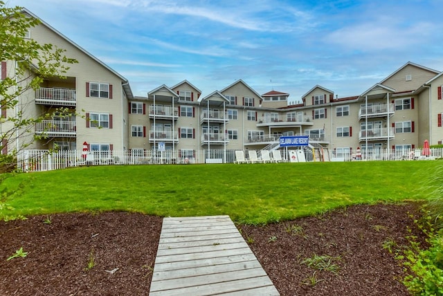 view of community featuring fence and a lawn