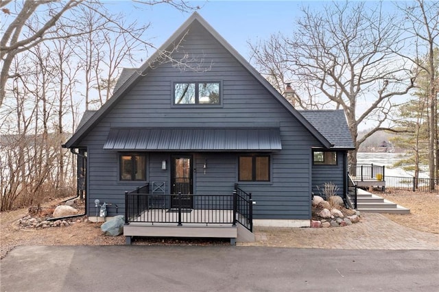 chalet / cabin featuring a chimney and fence