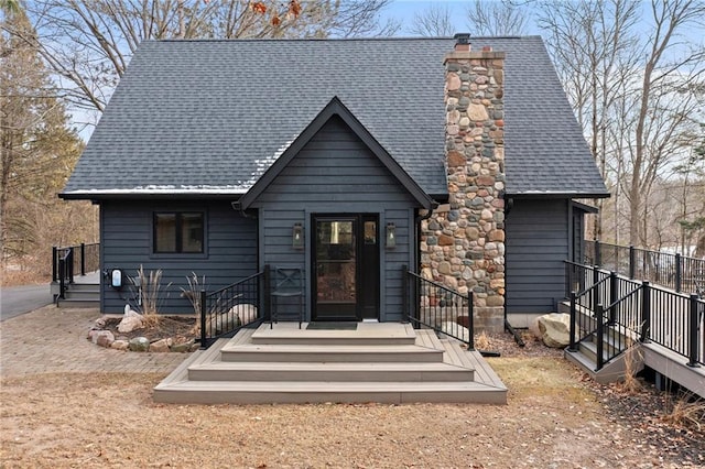 rustic home featuring a chimney and roof with shingles