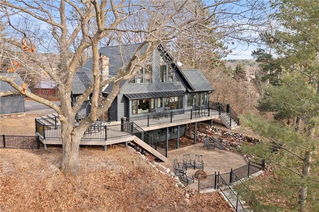 rear view of property with stairs, a deck, a shingled roof, and fence