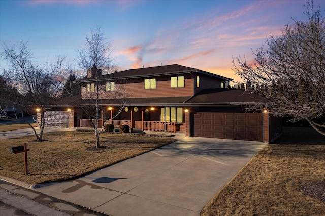 view of front of property featuring an attached garage, covered porch, and concrete driveway