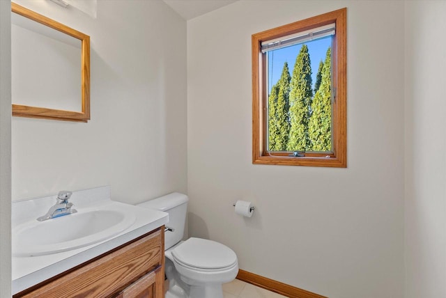 bathroom with vanity, toilet, and baseboards