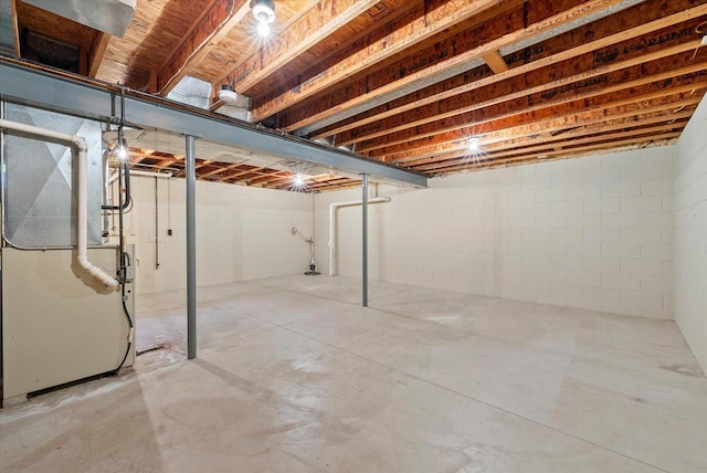 unfinished basement with heating unit and concrete block wall