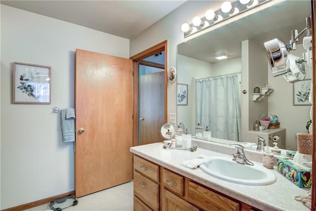 bathroom with a shower with shower curtain, vanity, and baseboards