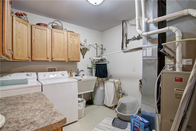 clothes washing area with cabinet space, washing machine and dryer, and a sink