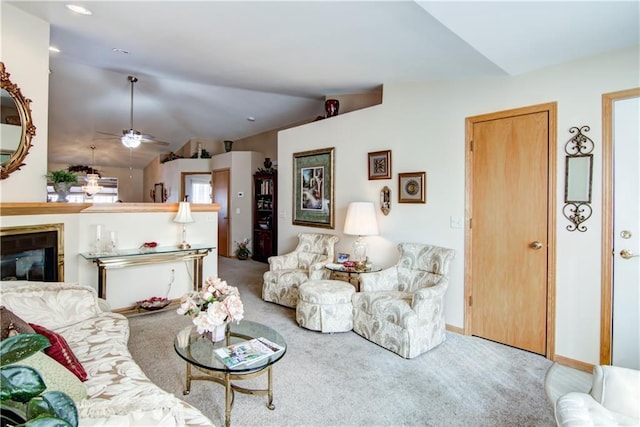 living room with carpet floors, ceiling fan, vaulted ceiling, and a glass covered fireplace