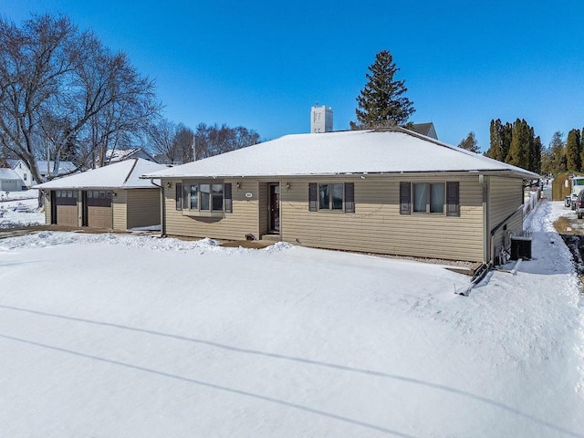 single story home featuring a garage, a chimney, and cooling unit