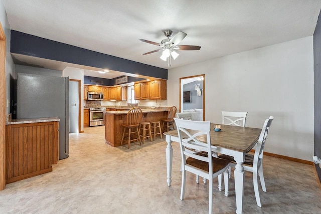 dining space featuring ceiling fan, light floors, and baseboards