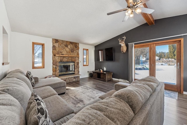 living area featuring a healthy amount of sunlight, vaulted ceiling with beams, and wood finished floors