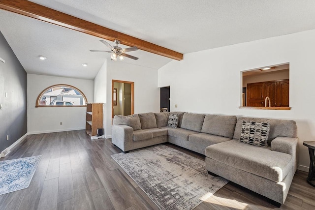 living area featuring baseboards, lofted ceiling with beams, a textured ceiling, and wood finished floors