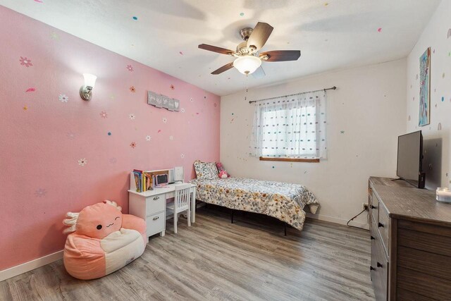 bedroom featuring a ceiling fan, baseboards, and wood finished floors