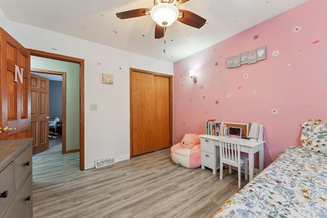 bedroom featuring light wood finished floors, baseboards, visible vents, ceiling fan, and a closet