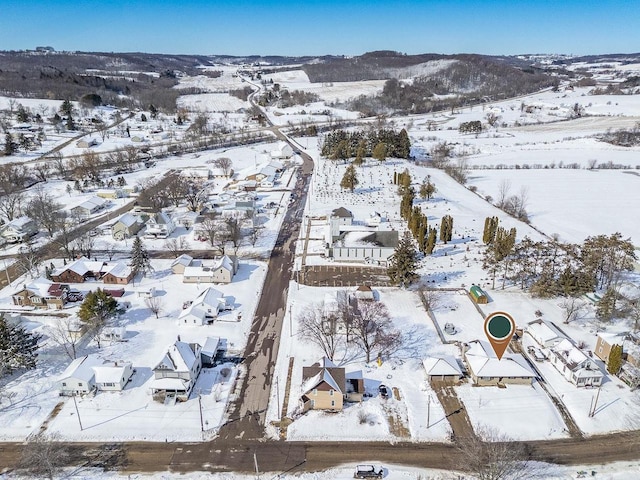 snowy aerial view featuring a mountain view and a residential view