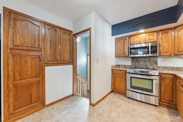 kitchen with brown cabinets, baseboards, and stainless steel appliances