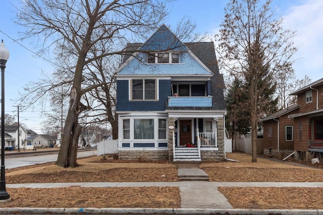 view of front of house with fence, a porch, and roof with shingles