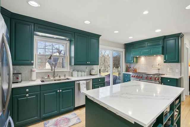 kitchen featuring stainless steel appliances, plenty of natural light, a sink, and light wood-style flooring