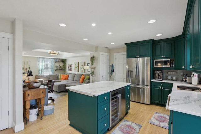 kitchen featuring appliances with stainless steel finishes, a kitchen island, and green cabinetry