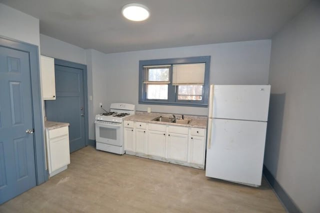 kitchen with a sink, baseboards, white appliances, and white cabinetry