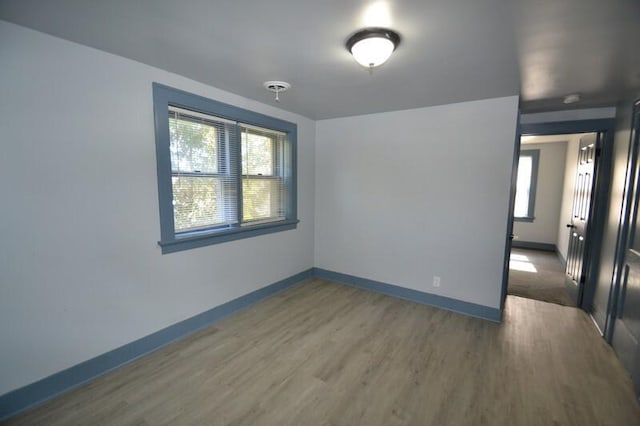 unfurnished room with baseboards and wood finished floors