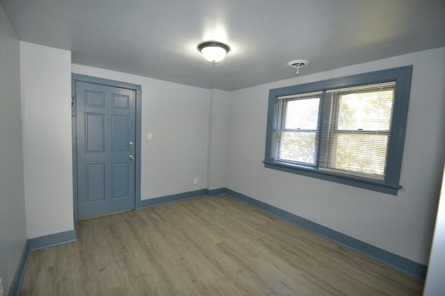 spare room featuring baseboards and wood finished floors