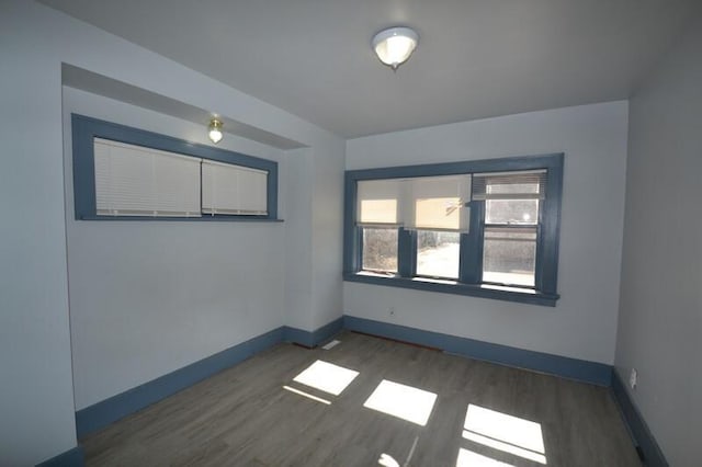 spare room featuring wood finished floors and baseboards