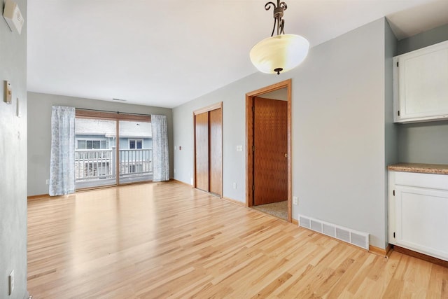 interior space with light wood-style flooring and visible vents