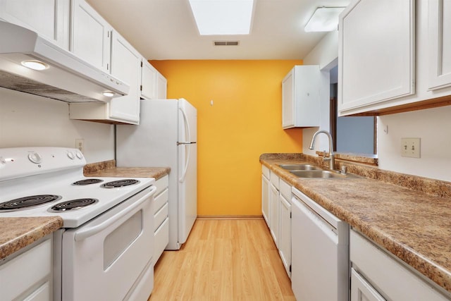 kitchen with white appliances, white cabinets, light wood-type flooring, under cabinet range hood, and a sink