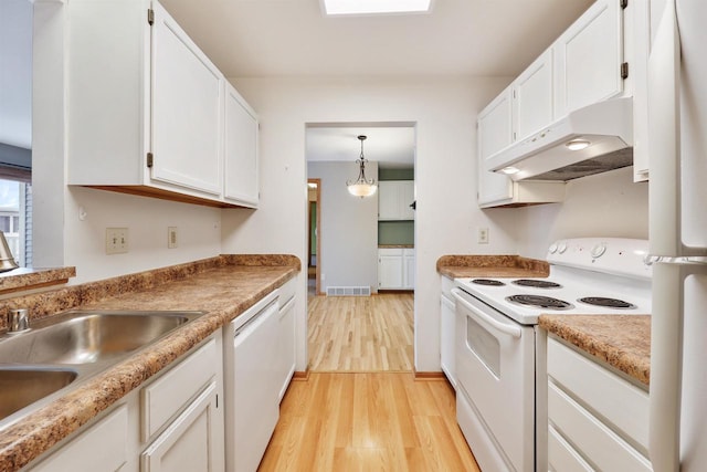 kitchen with light wood-style flooring, under cabinet range hood, white appliances, white cabinetry, and visible vents