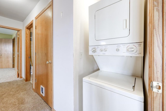 washroom featuring laundry area, visible vents, stacked washer / dryer, and carpet flooring