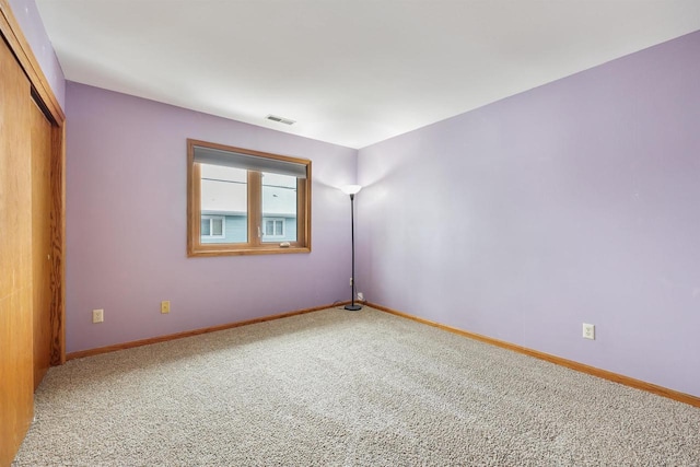 carpeted empty room with visible vents and baseboards