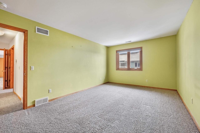 carpeted empty room with visible vents and baseboards