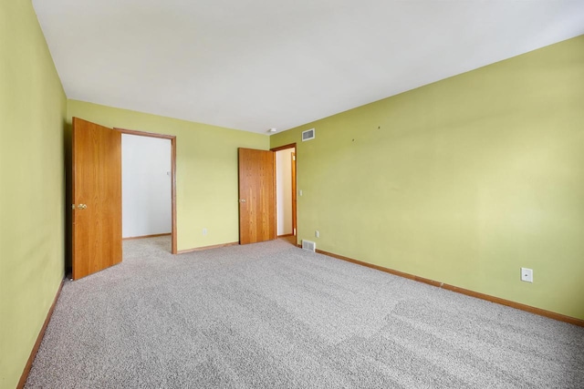 unfurnished bedroom featuring carpet, visible vents, and baseboards