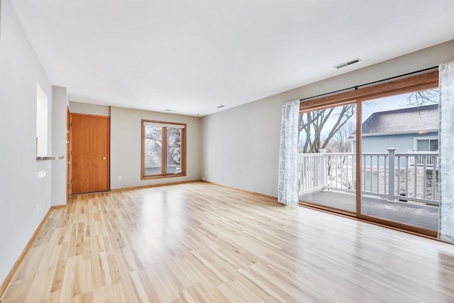 unfurnished living room with visible vents, a wealth of natural light, and light wood-style flooring