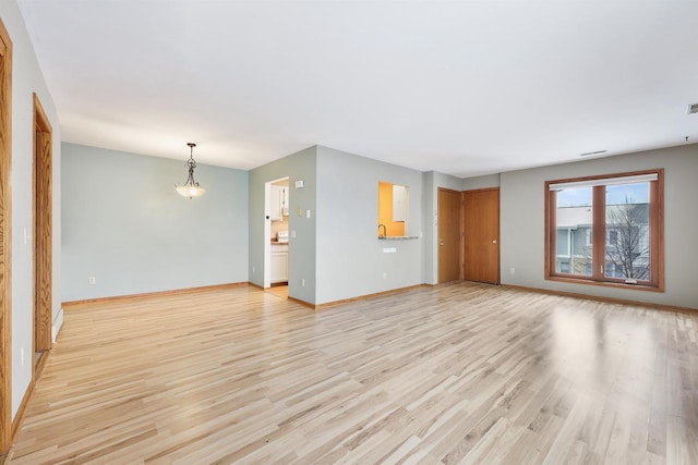 unfurnished living room featuring baseboards and light wood-style floors