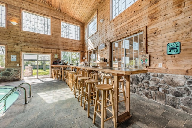 bar with vaulted ceiling, wood ceiling, and wooden walls