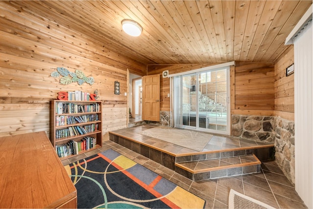 sitting room with wood ceiling, wooden walls, and vaulted ceiling