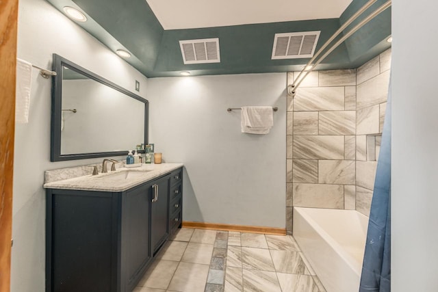 bathroom with bathtub / shower combination, vanity, visible vents, and baseboards