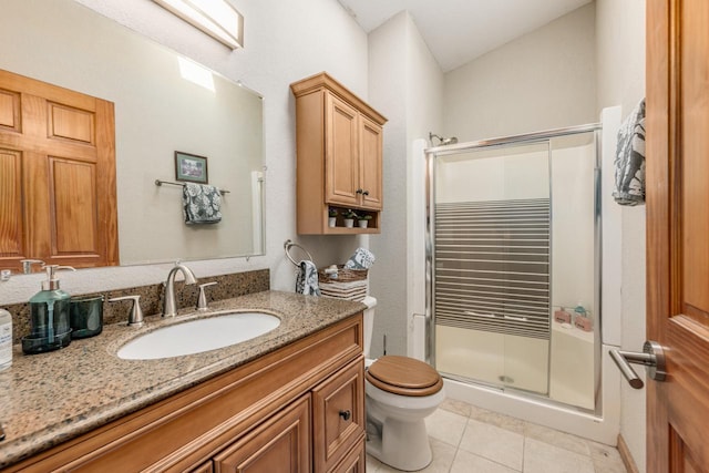 bathroom with toilet, a shower stall, vanity, and tile patterned floors