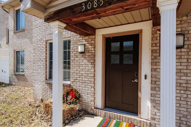 view of exterior entry with brick siding