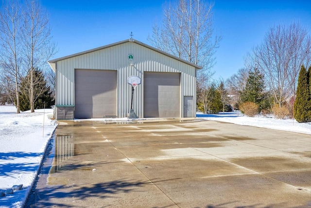 snow covered garage featuring a detached garage