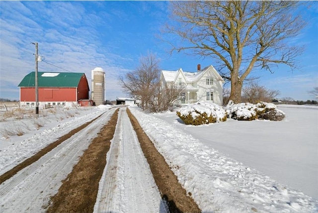 view of street featuring driveway and a barn