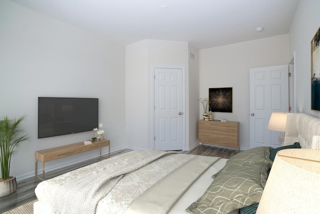 bedroom featuring visible vents, baseboards, and wood finished floors