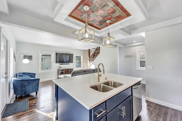 kitchen with blue cabinets, dishwasher, open floor plan, and a sink